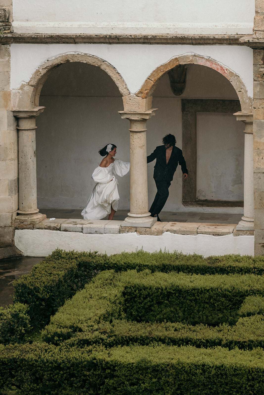 Wedding Couple runs through a historical venue.