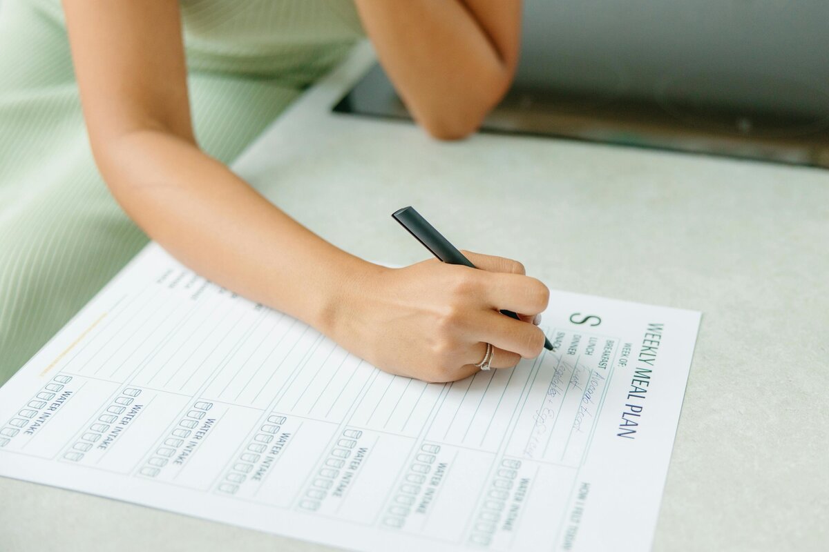 Woman writing a weekly meal plan