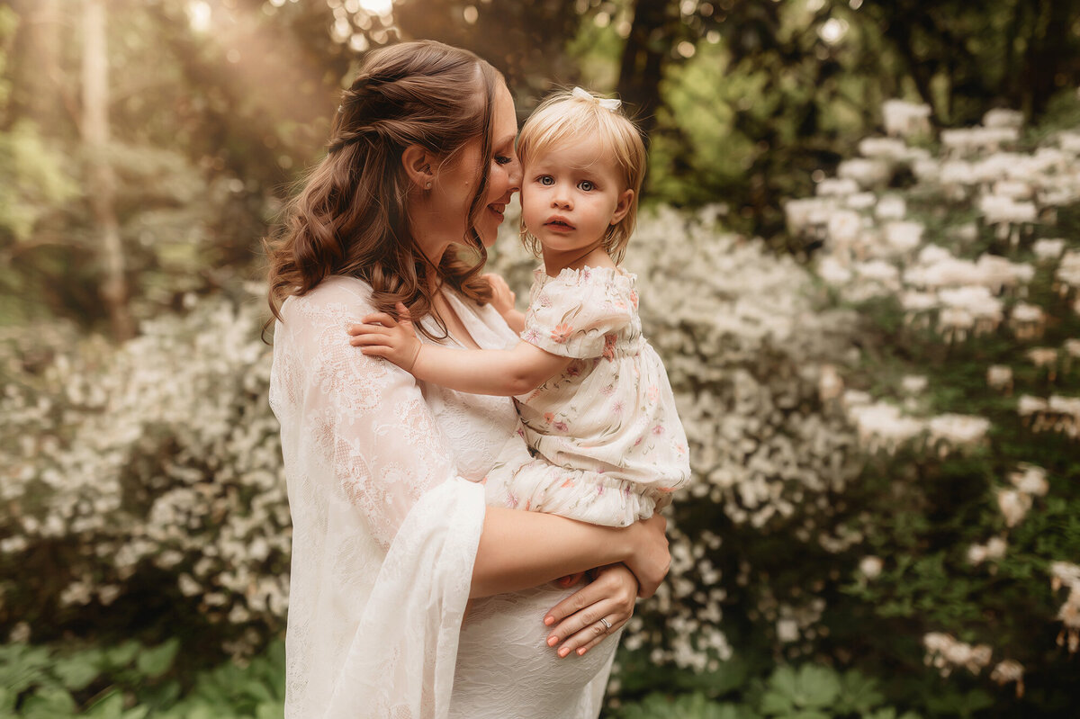 Expectant mother embraces her toddler during Maternity Photoshoot at Biltmore Estate in Asheville, NC.