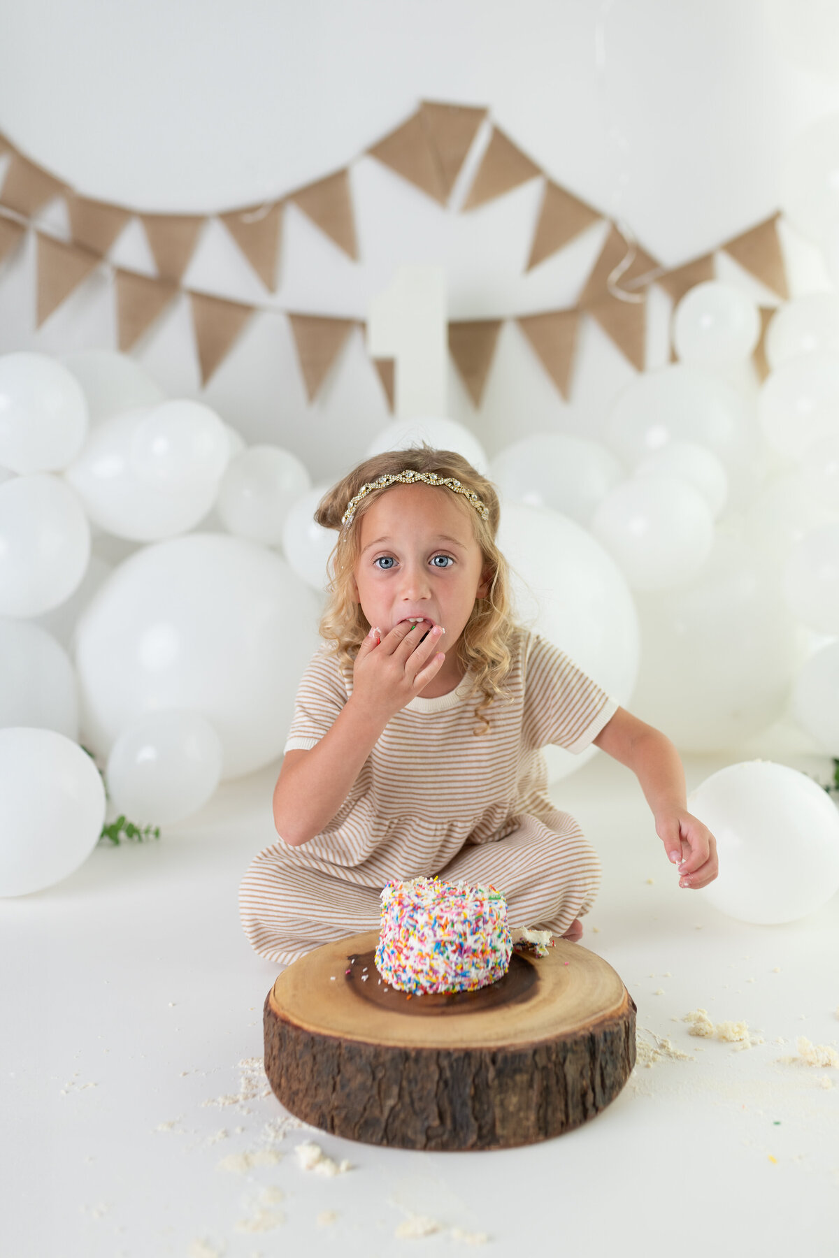 Milestone birthday session of a girl enjoying her cake smash—sprinkles, joy, and all the messy fun.