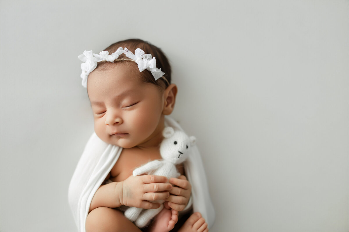 Baby with his mouth open laying on a knitted light brown blanket
