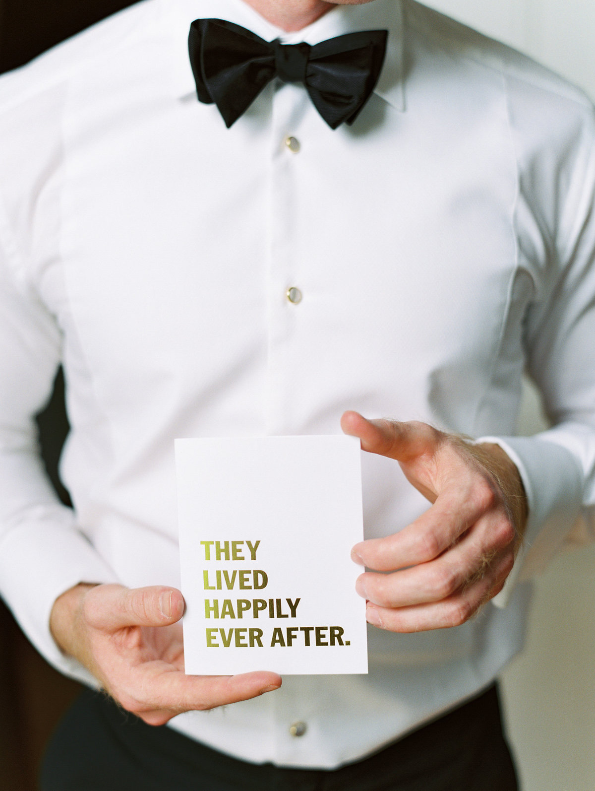 a groom holding a note from his bride on their wedding morning