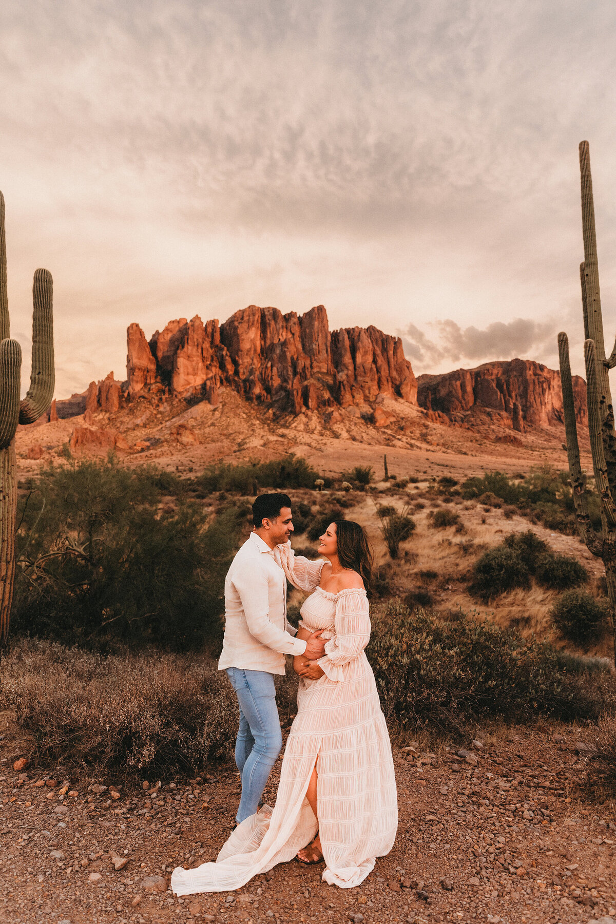 mixed race couple posing for maternity session at lost dutchman state park in arizona for maternity session