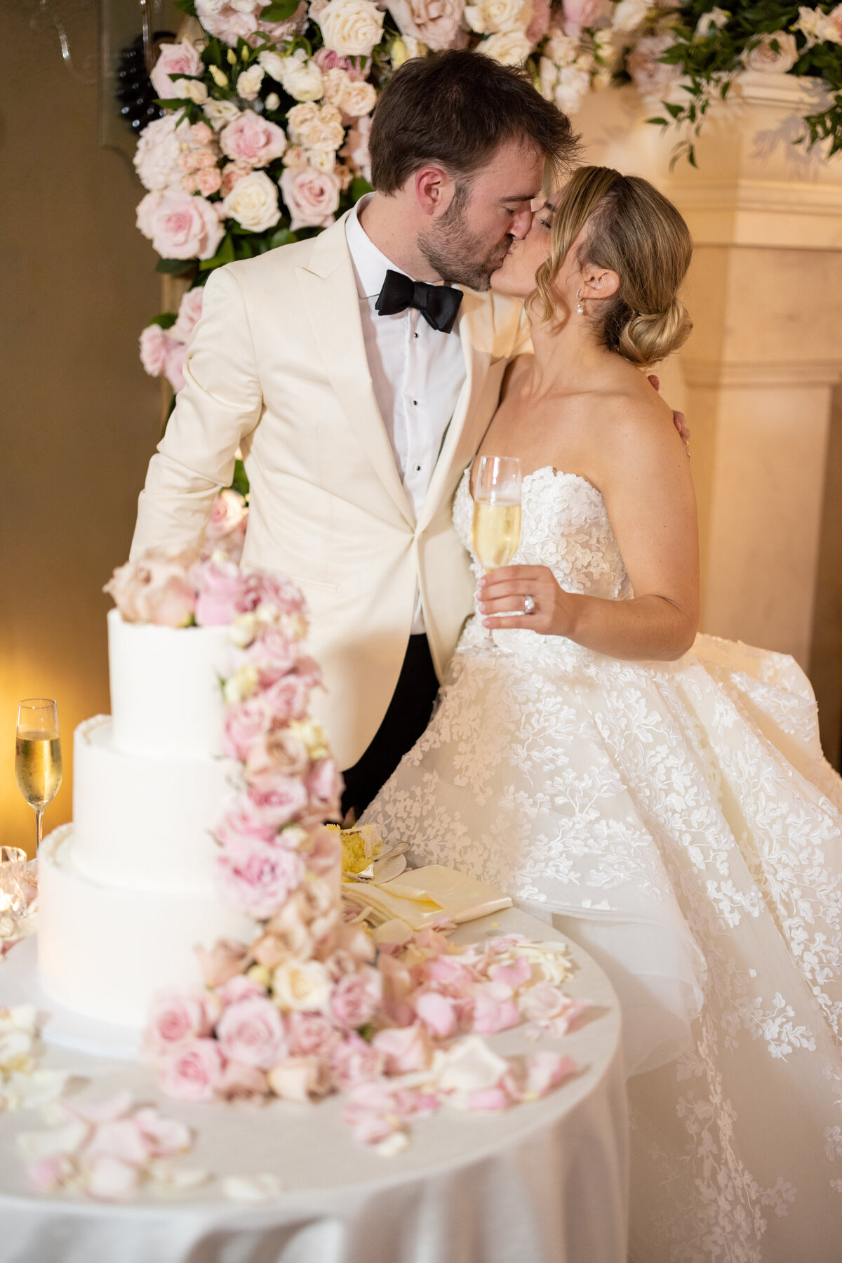 bride and groom kiss while cutting cake