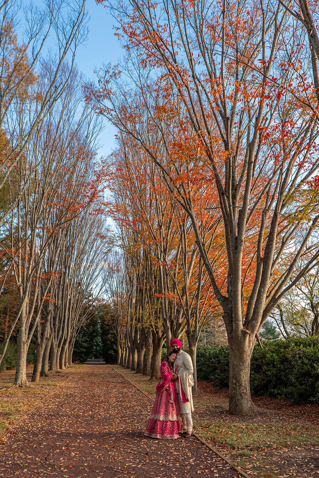 A newlywed couple hugging on a path in a park 