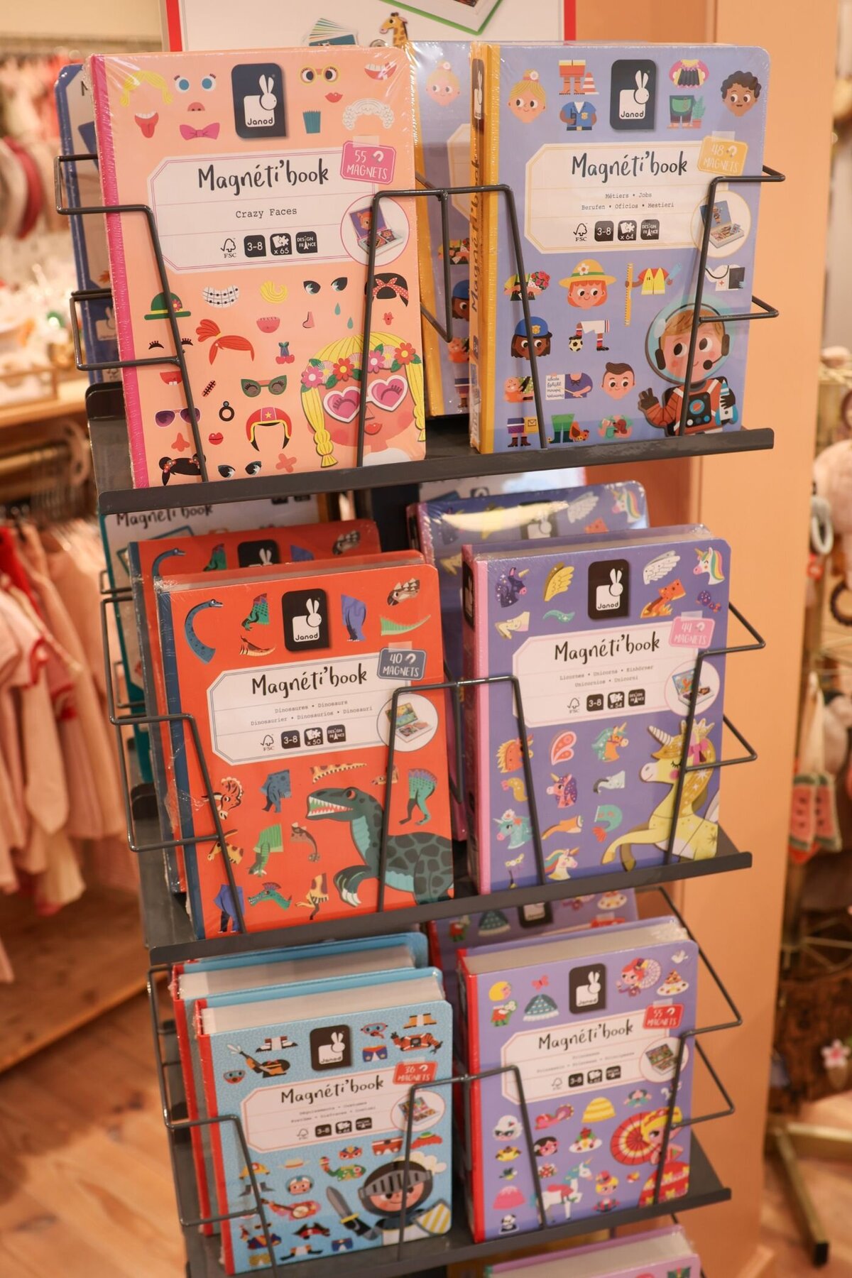 Een metalen rek gevuld met magnetische kinderboeken in een winkel.