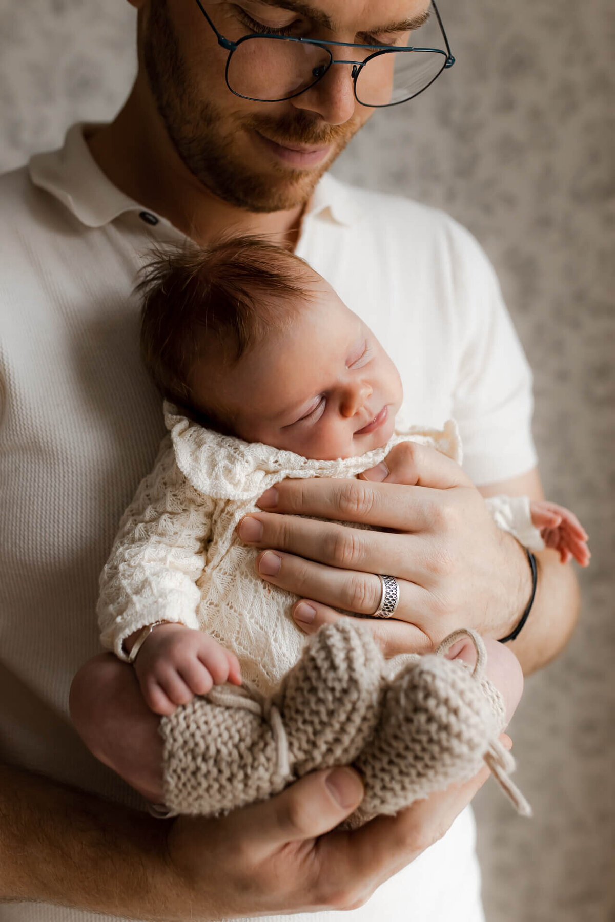 Newbornshoot baby in de handen van papa