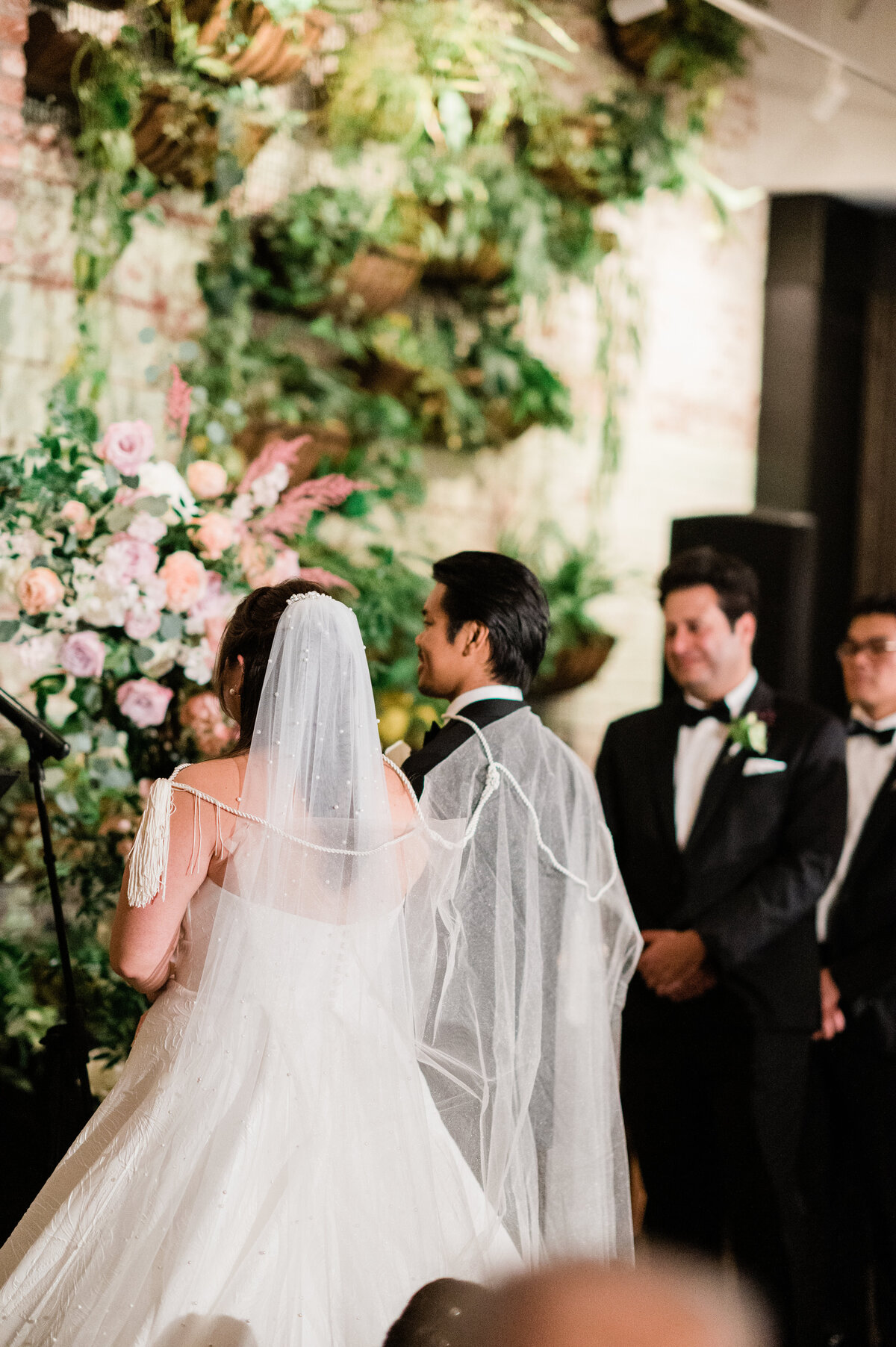 Bride and groom hold hands at the altar