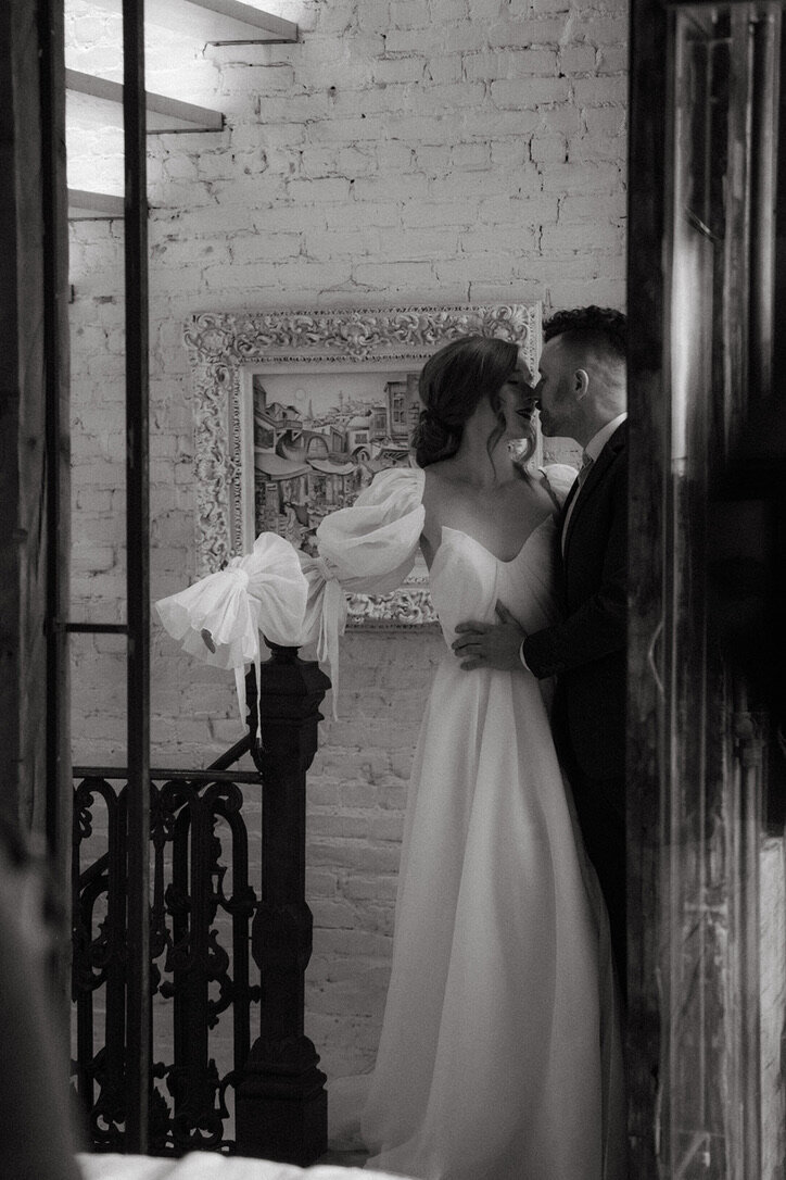 Bride wearing low bun kissing groom