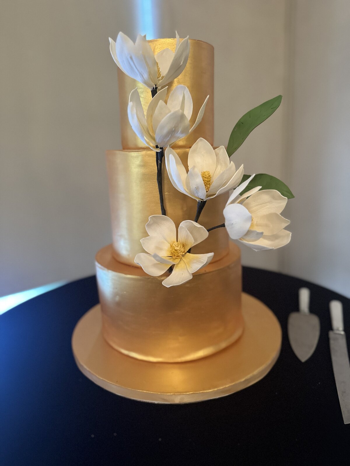 3 tier gold wedding cake with sugar magnolias