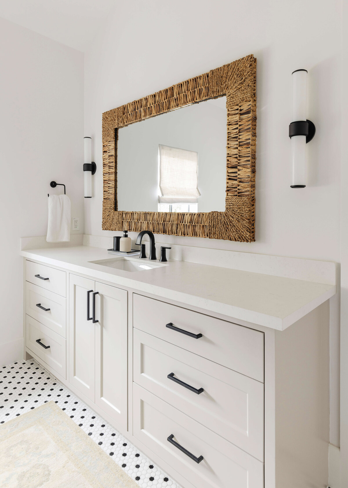 oyster creek studios missouri city new build white bathroom with black hardware and wicker mirror and tiled floor