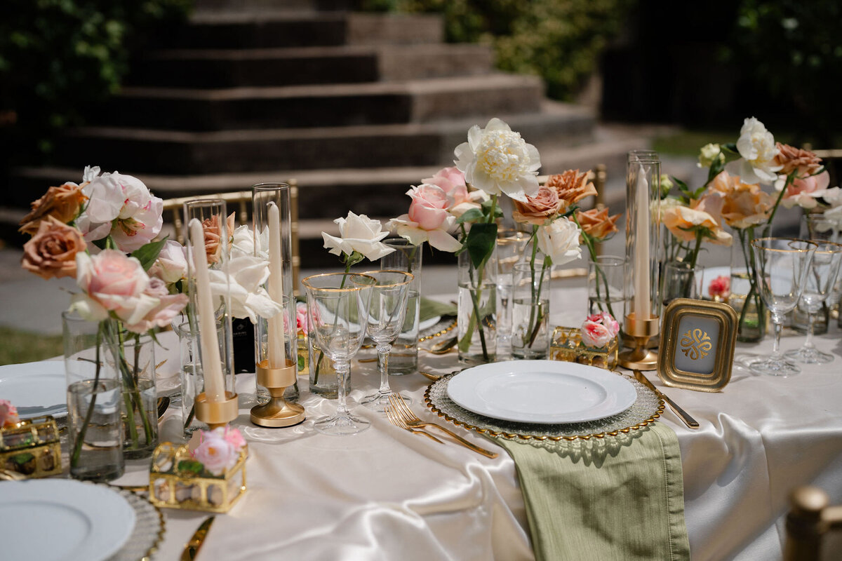 Elegant fine linen table cloth, gold rim glasses, sage napkins, gold decor and flatware, roses and peonies