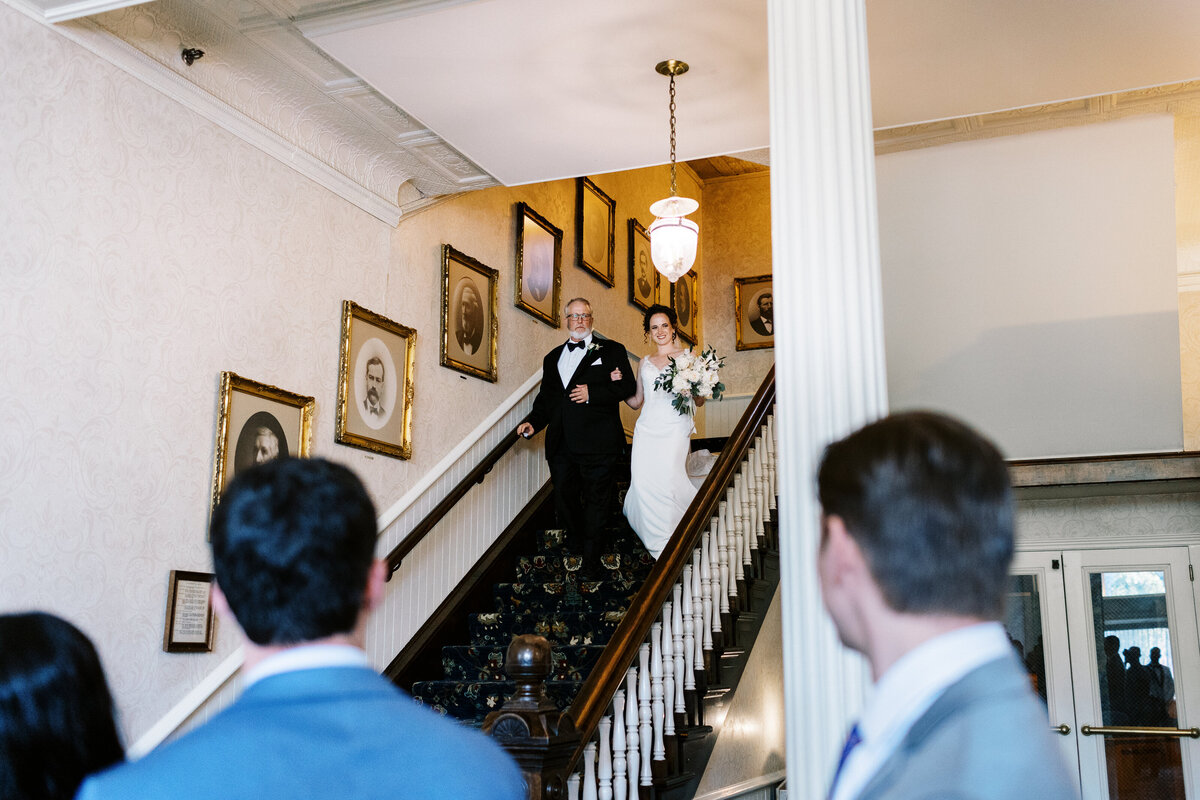 here comes the bride walking down the stairs at St James Hotel wedding