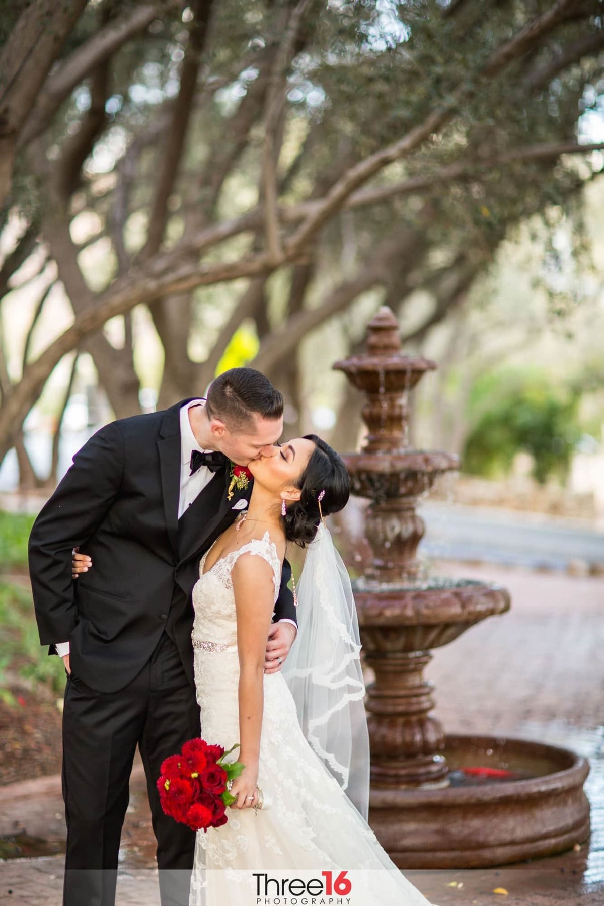 Bride and Groom share a kiss next to the water fountain at the Padua Hills Theater