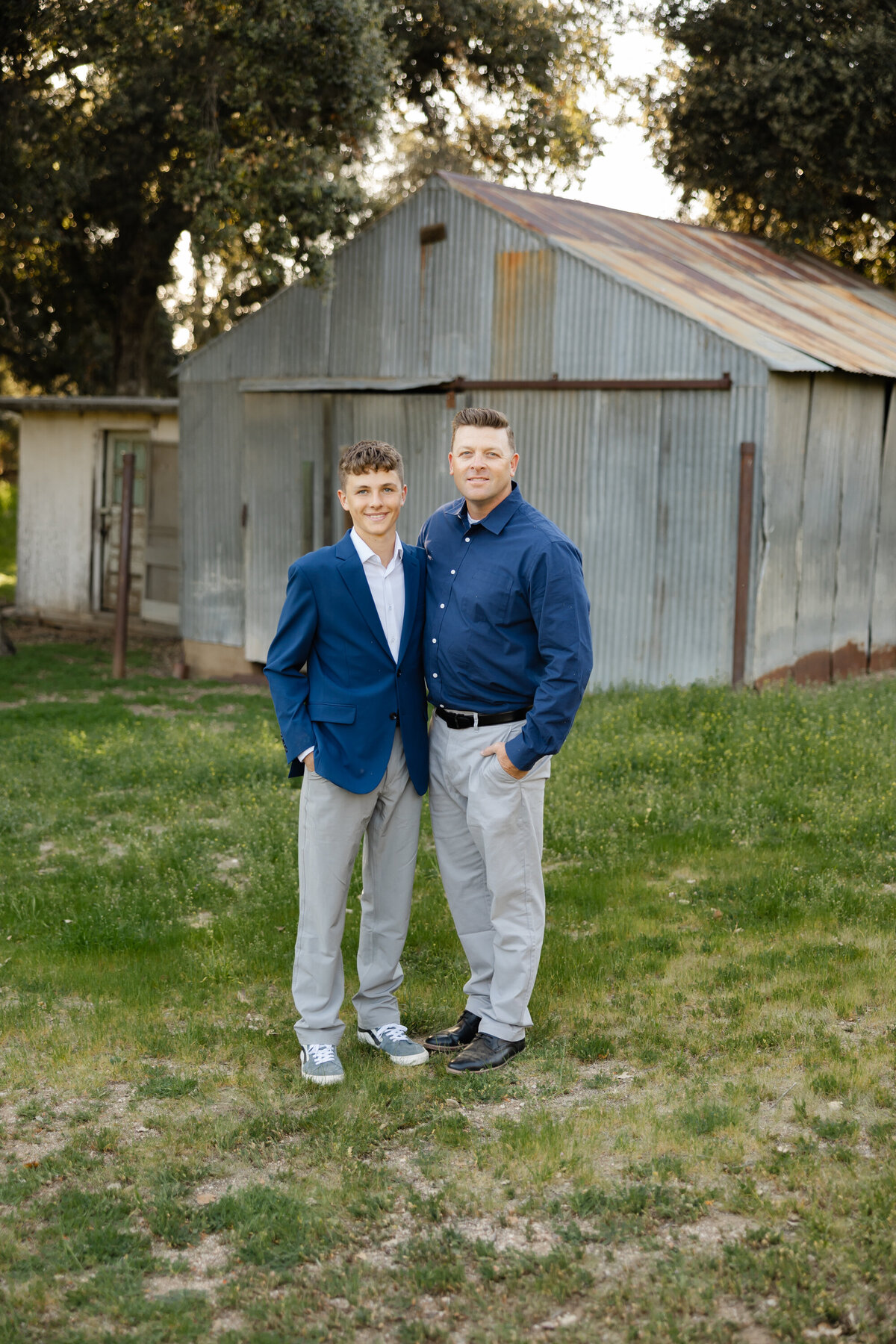 Father and son standing together outdoors, dressed in coordinated navy and gray outfits. Photographed by Yucaipa family photographer Kaitlyn Dawn Photography.