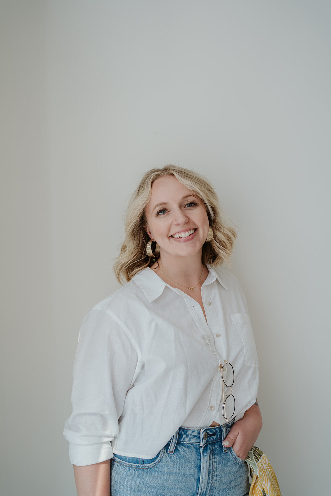 Professional branding headshot of a woman smiling in natural window light during a Wildher and Co session in Kalamazoo Michigan.
