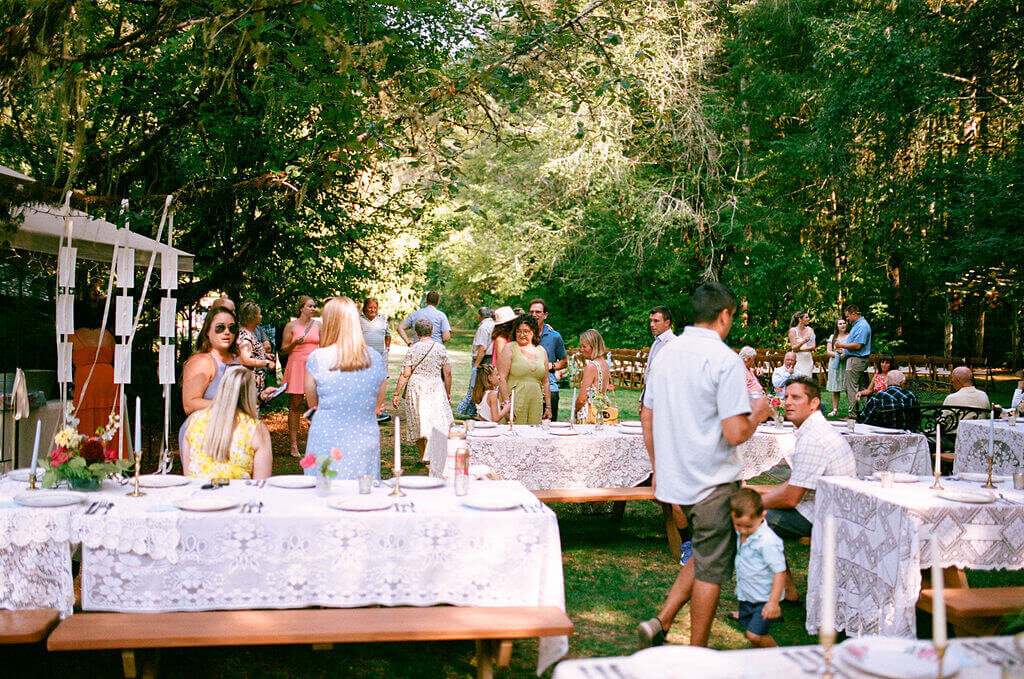 People celebrating at an outdoor wedding reception planned by Birdie June Events.