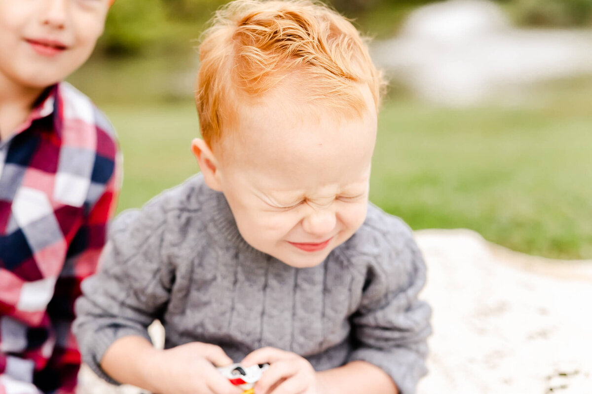Laughing red headed boy at family session near Naperville, IL.
