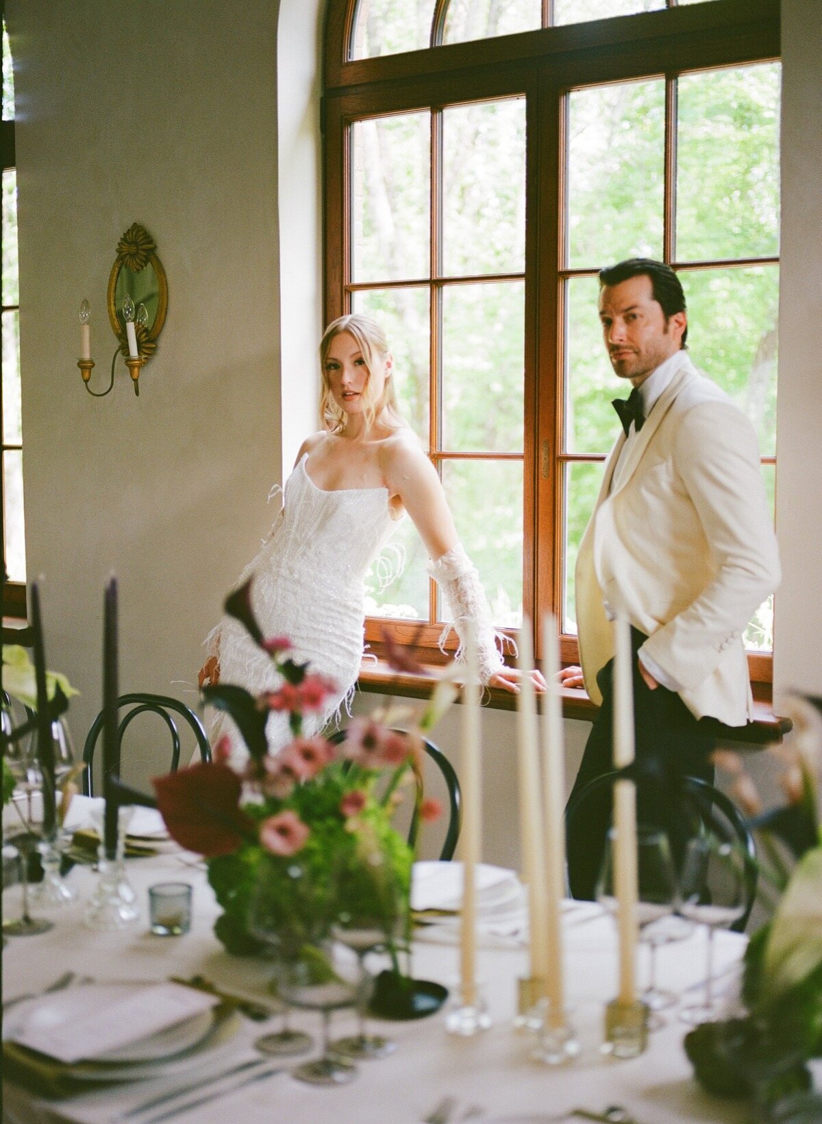The newlyweds stand by the big window for their wedding at Chateau Ste Agnes.