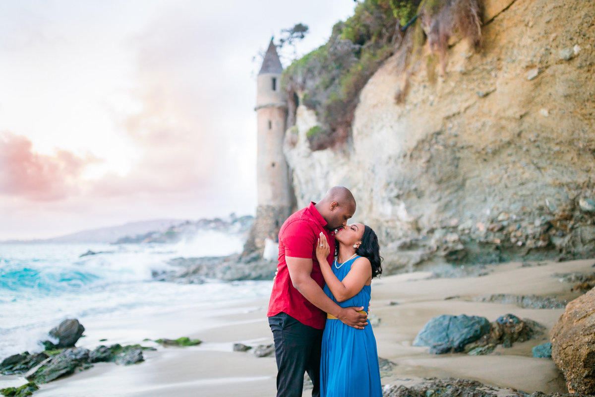 engaged couple kiss on the beach
