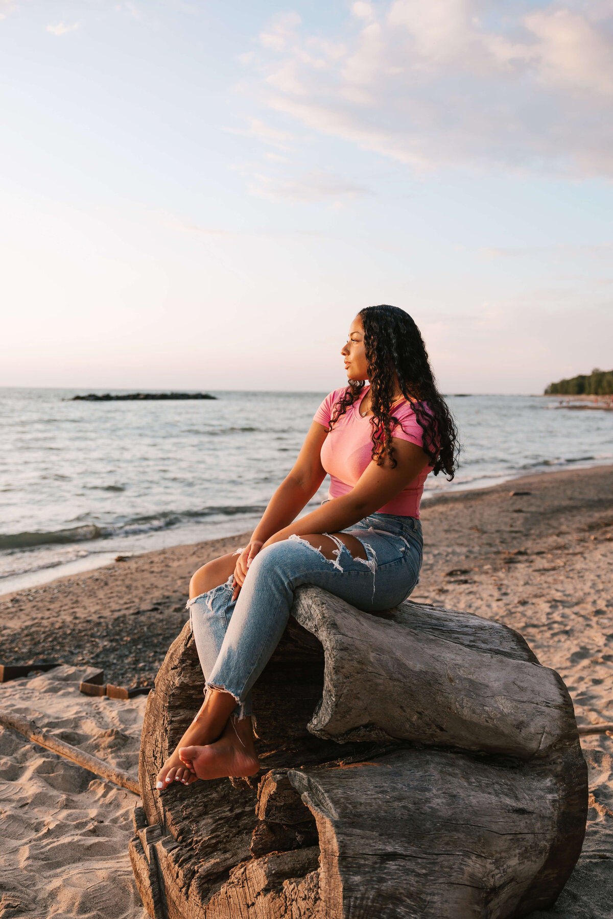 Erie Pa high school senior sitting on a log on the beach in Erie Pa