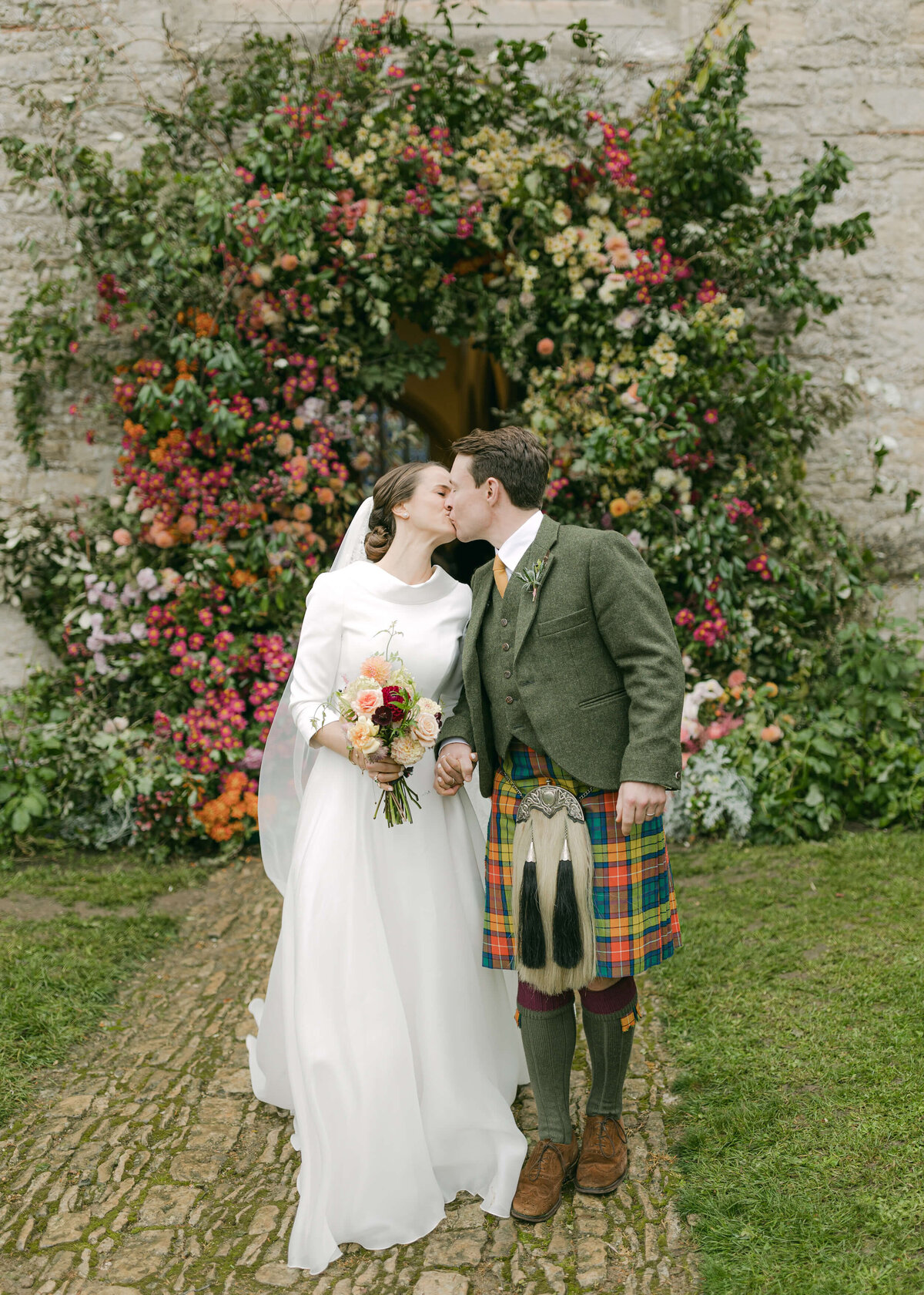 chloe-winstanley-wedding-oxford-gsp-couple-kiss-flower-arch