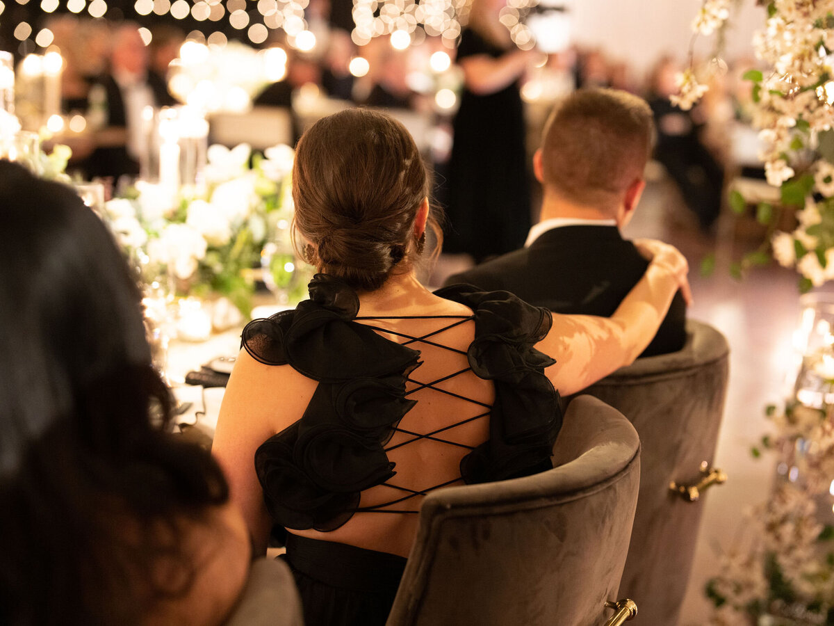 Wedding guests sitting at the table with their back turned away. 