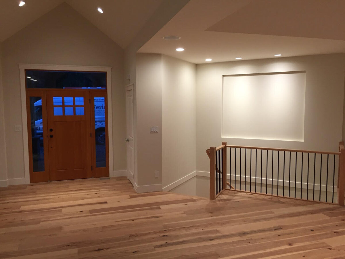 Traditional craftsman entry design with hardwood flooring and pot lights.