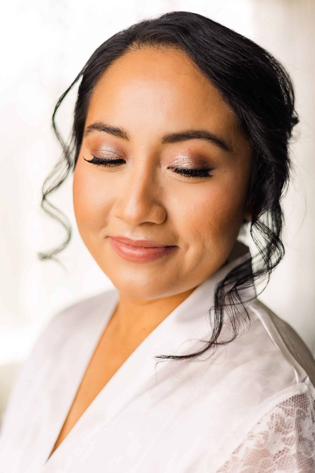 Bright photograph of bride and robe prior to wedding with her finished make up