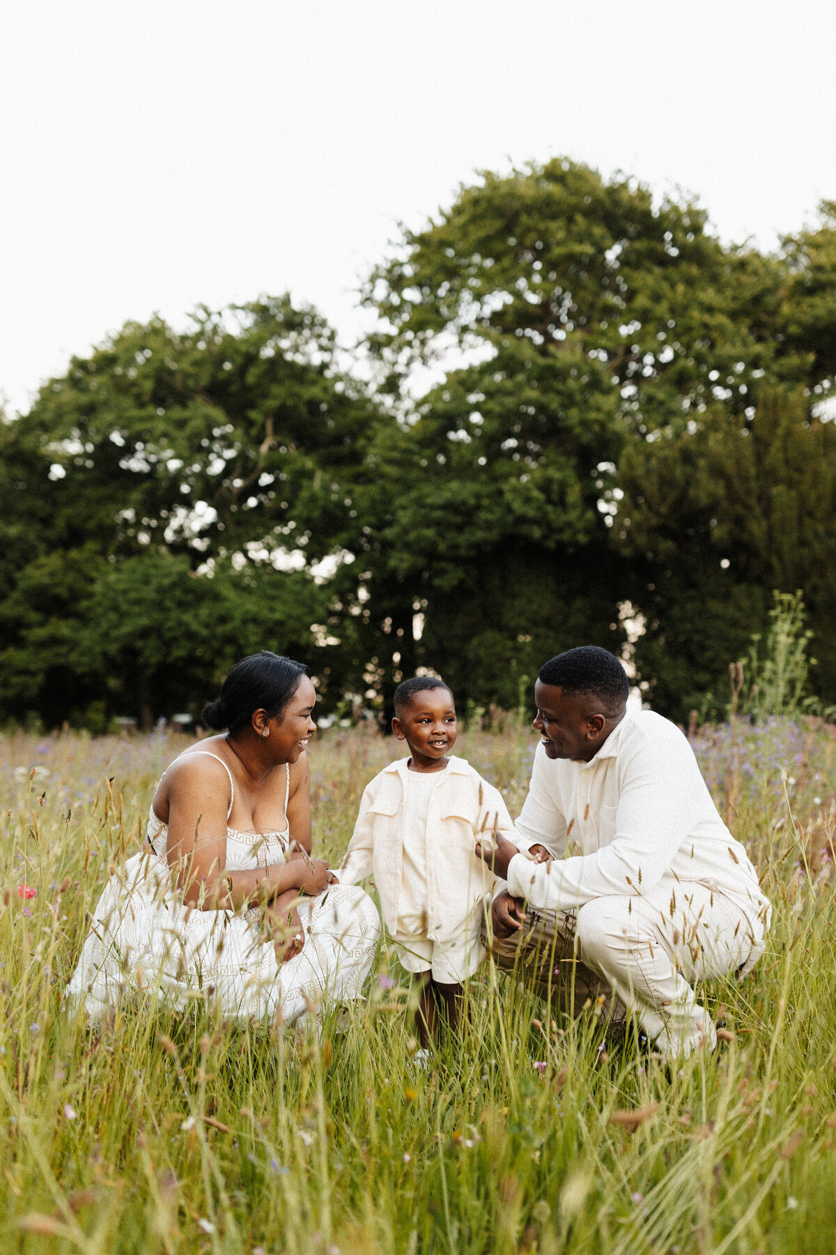 a mother and father looking at their son as he laughs at a prompt given by local photographer lucy jane photography in christchurch
