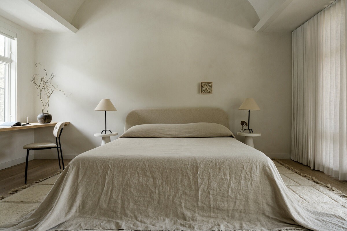 house-franc-casita-cottage-guest-house-bedroom-limewash-archway-cozy-wool-rug-minimal-linen-drapery-bedding-home-office-austin-texas-westlake