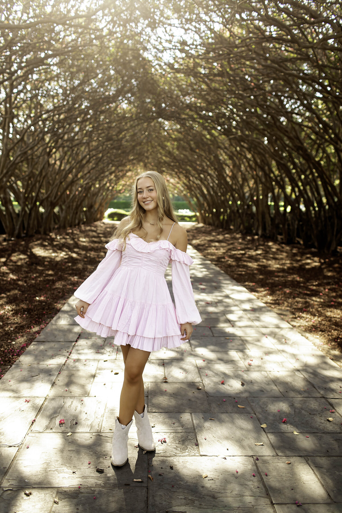 A senior girl twirls in a flowy dress, showcasing her playful side during a photoshoot