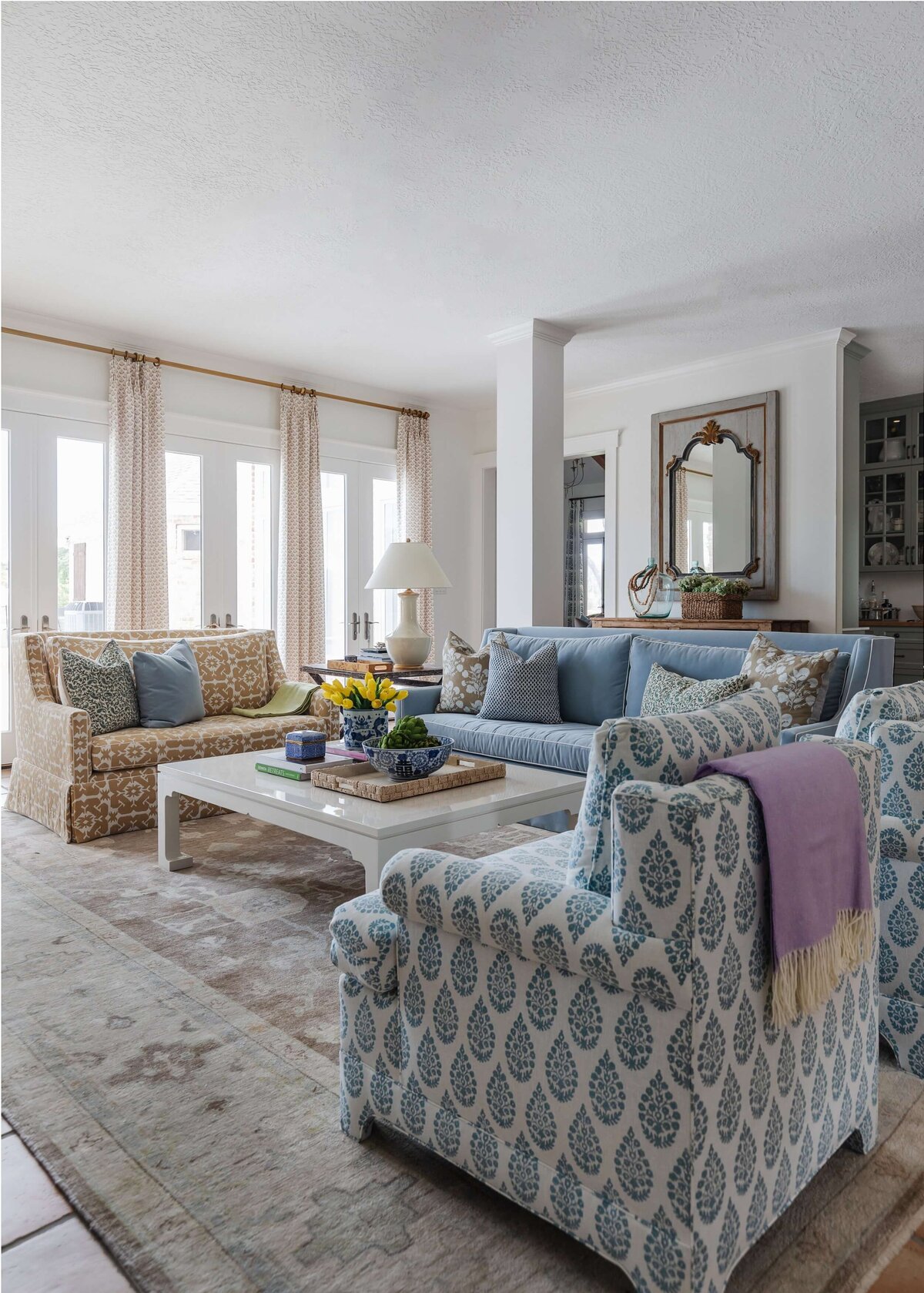oyster creek studios home on the range blue and white armchair blue sofa and brown and white patterned armchair around white coffee table in living room
