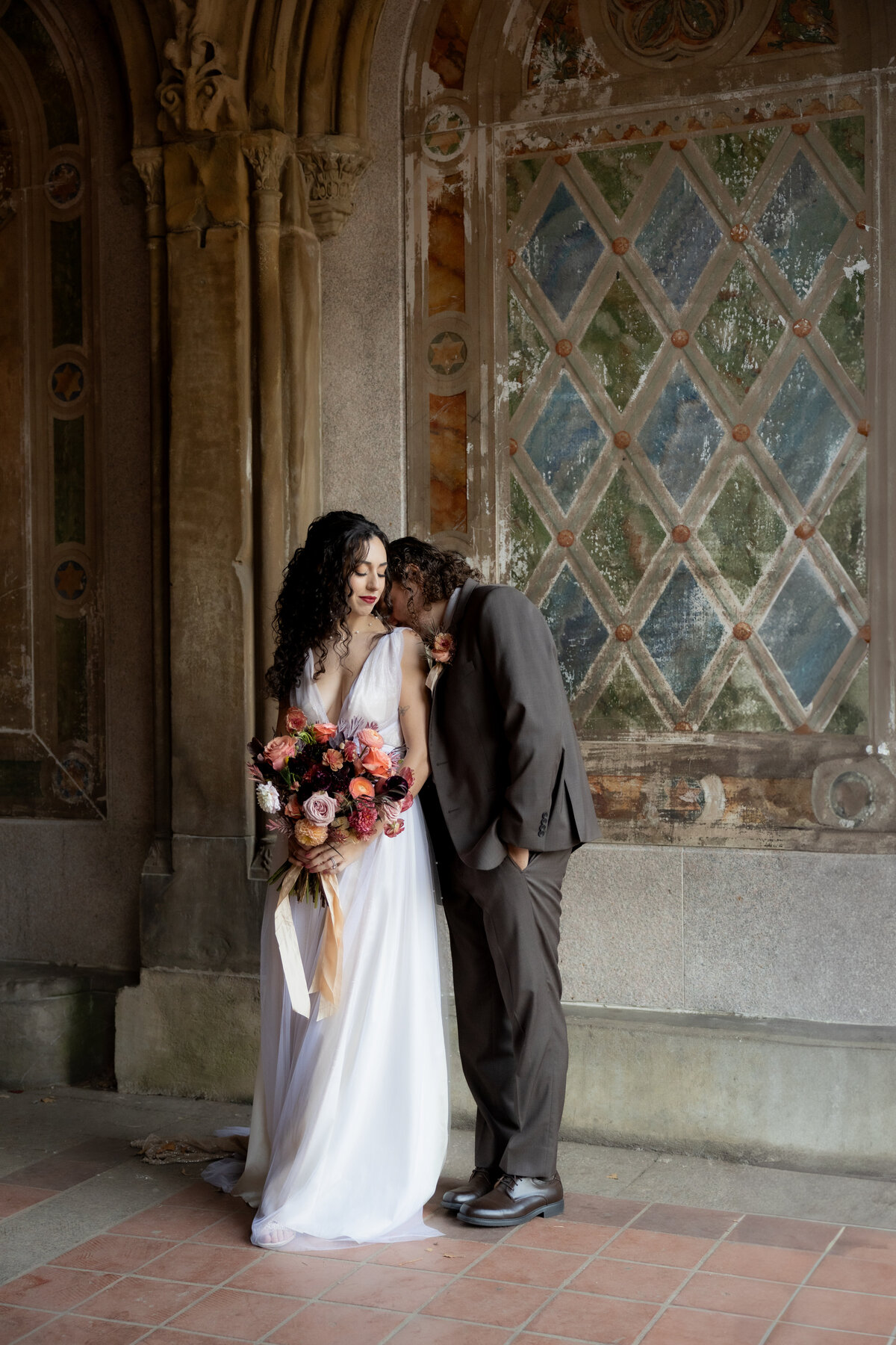 The couple sharing a tender moment beneath Central Park’s beautiful stone arches.