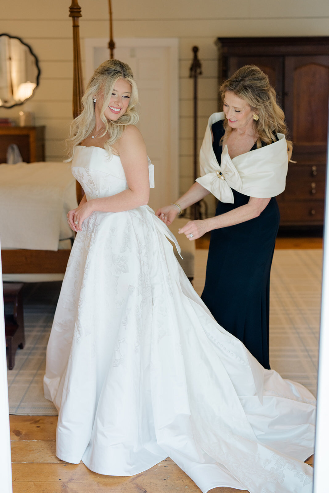 Mother helps bride into her wedding gown during elegant getting-ready photos at Old Edwards Inn in Highlands, North Carolina.
