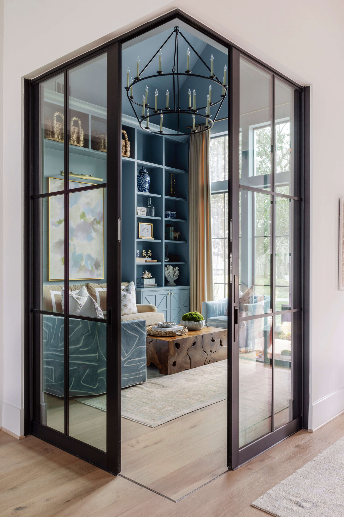 oyster creek studios missouri city new build entry to living room with chandelier blue walls and shelving