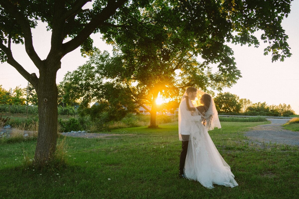 couple under a veil looking at each other during sunset