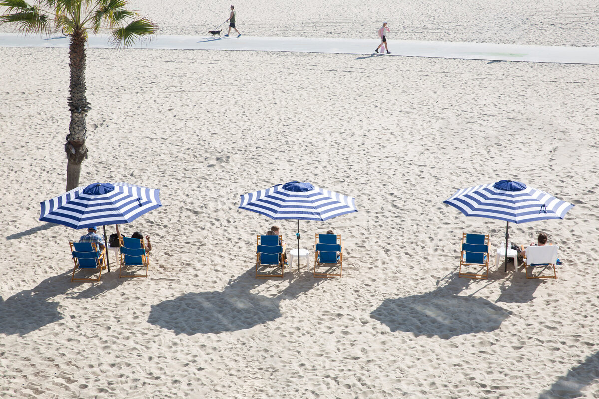 People sitting on the beach under umbrellas