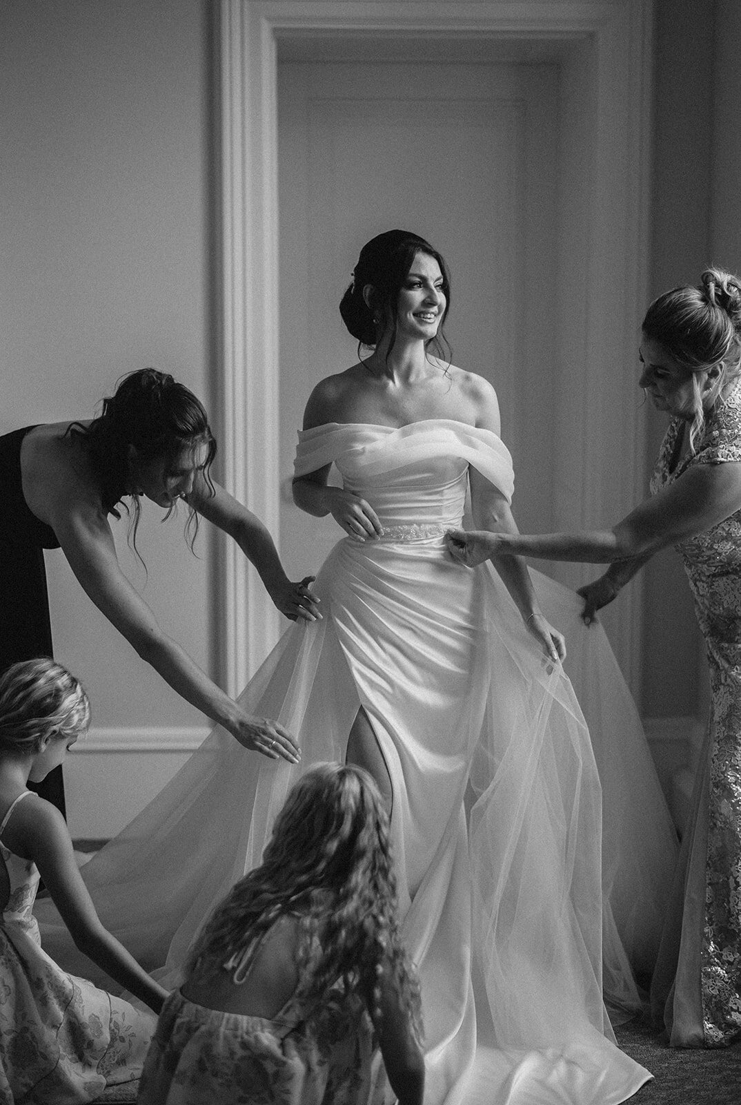bride has family help her fluff her dress at her wadsworth mansion wedding photo by cait fletcher photography
