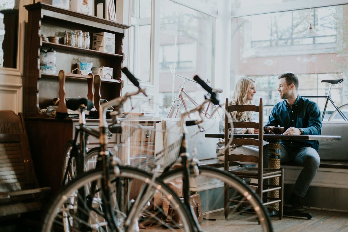 Engagement couple sitting and drinking coffee at Heritage Coffee shop in Chicago captured by an Indianapolis wedding photographer