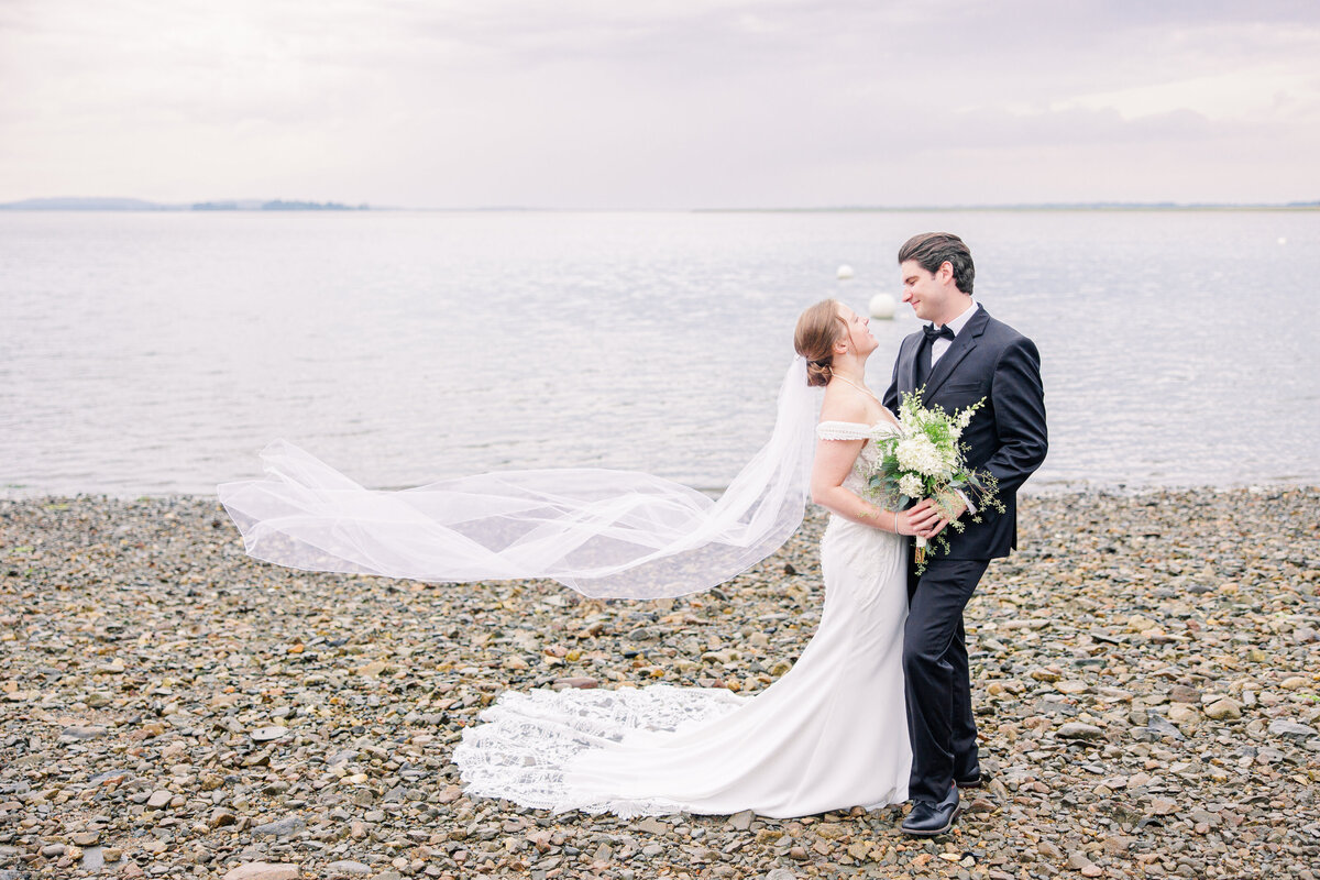 Bride and groom hugging with veil blowing in the breeze representing romantic Boston wedding images