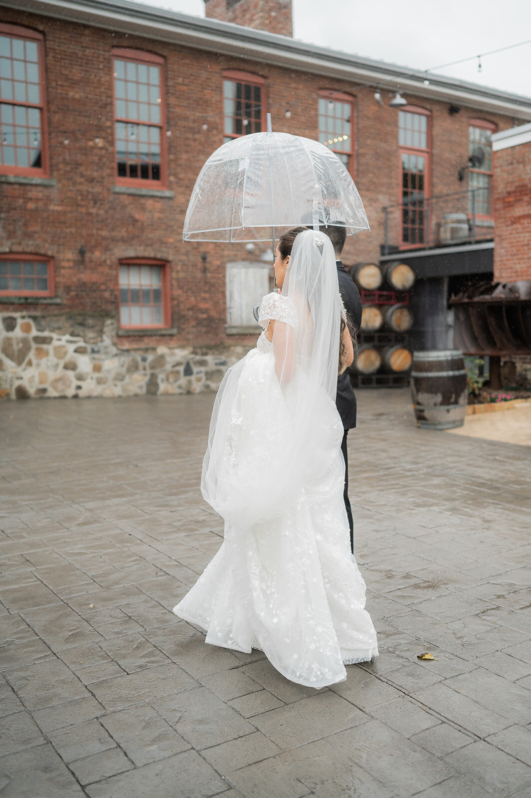 bride and groom take a stroll in the rain on wedding day