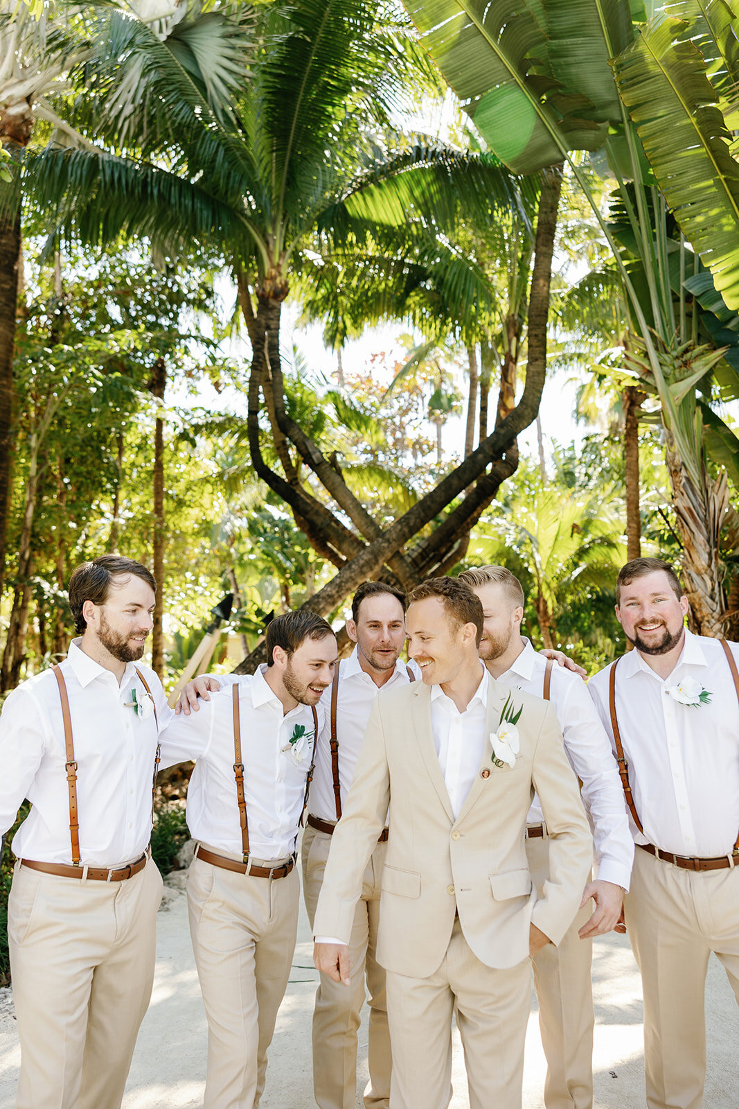  Hunter and his groomsmen stroll along a tropical garden path, sharing laughs before the ceremony.