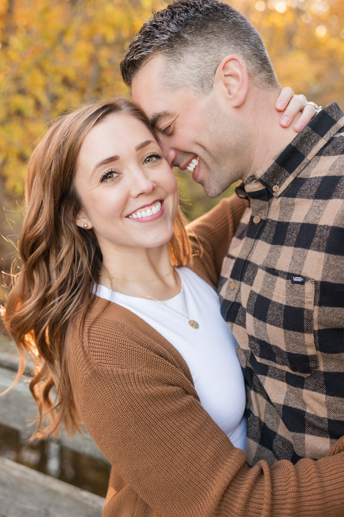 A couple is holding each other with the wife smiling at the camera