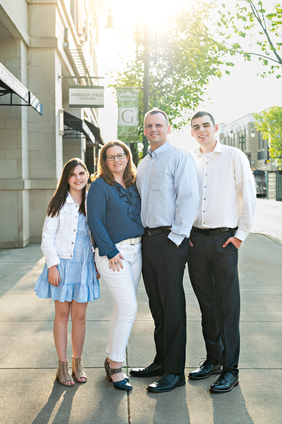 A family poses on the sidewalk in downtown Huntsville alabama