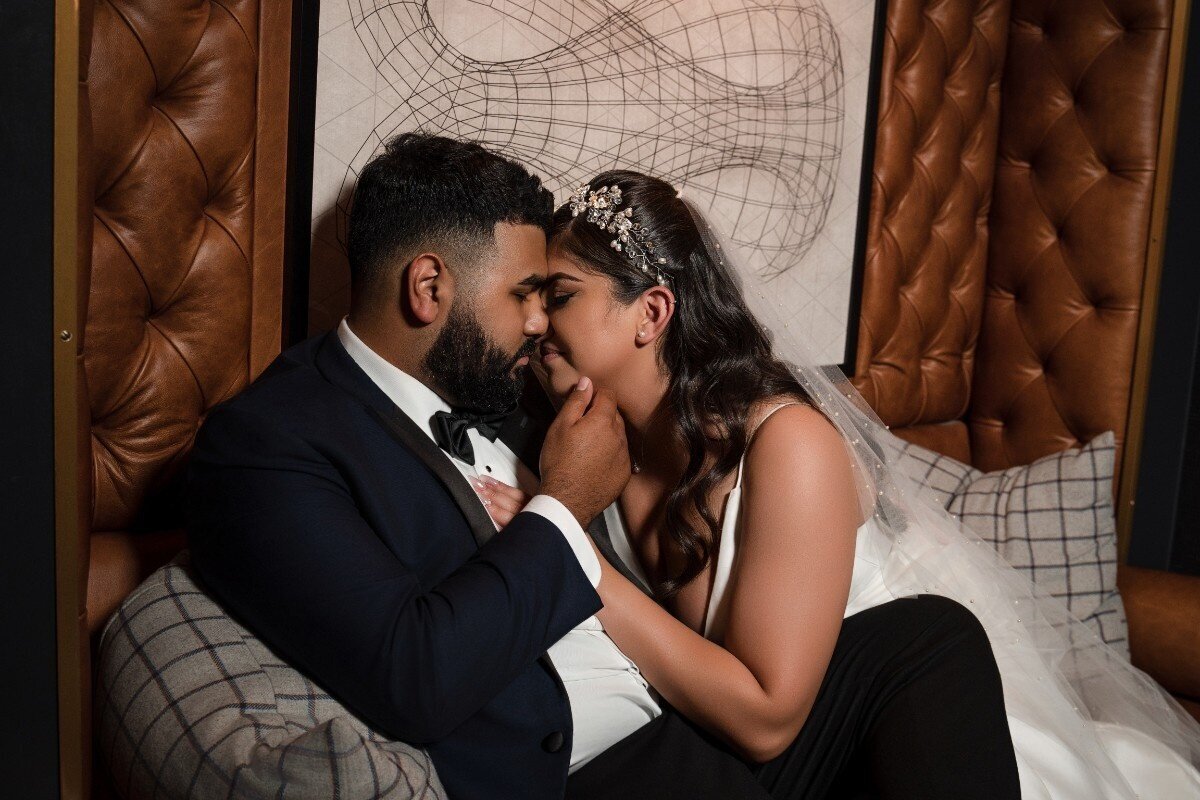 Romantic moment of bride and groom touching foreheads in a quiet lounge at The Union Club Hotel at Purdue University.