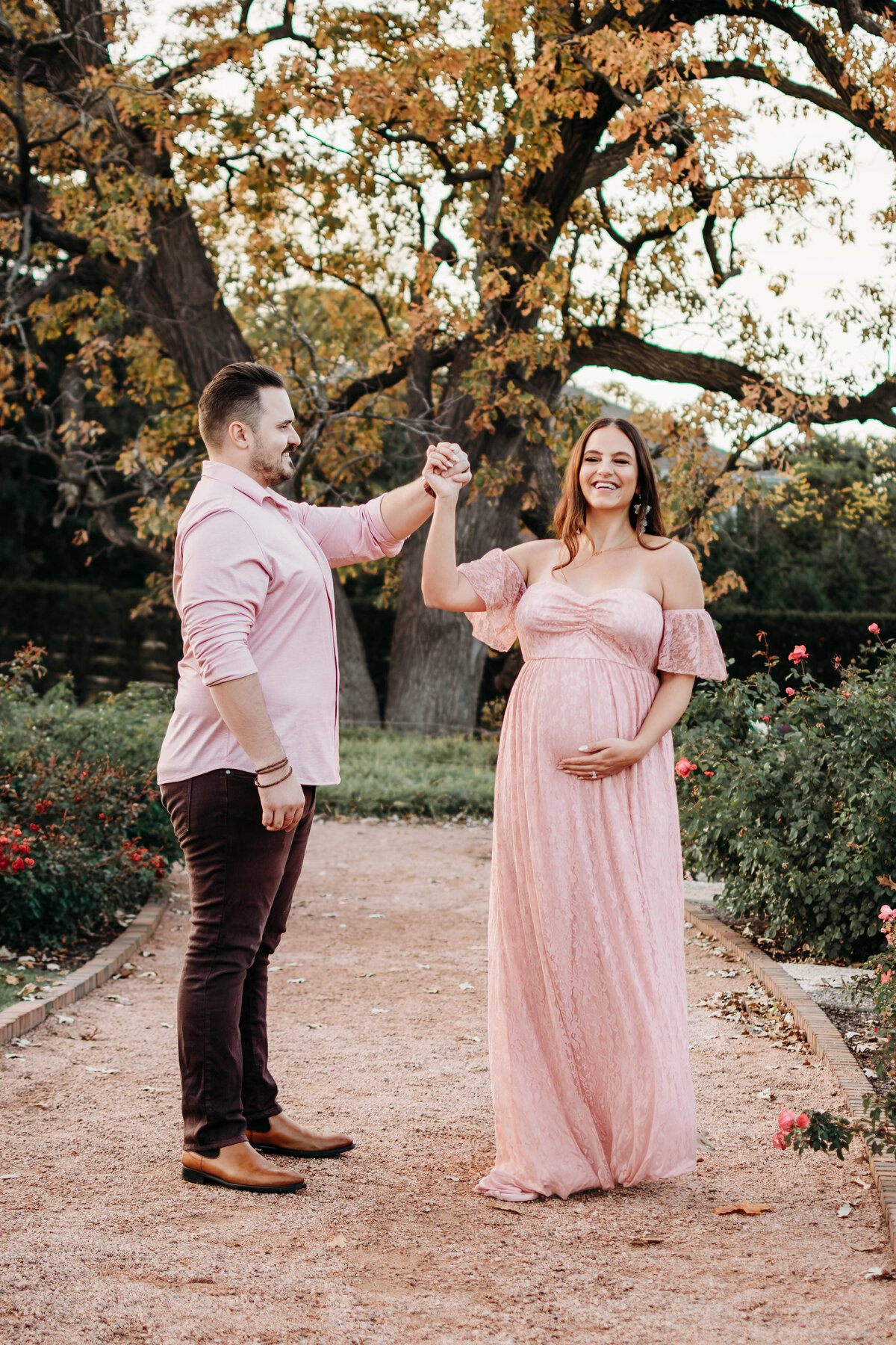 Soon to be mom and dad dancing in a field of roses during a maternity photoshoot, Chicago Suburbs