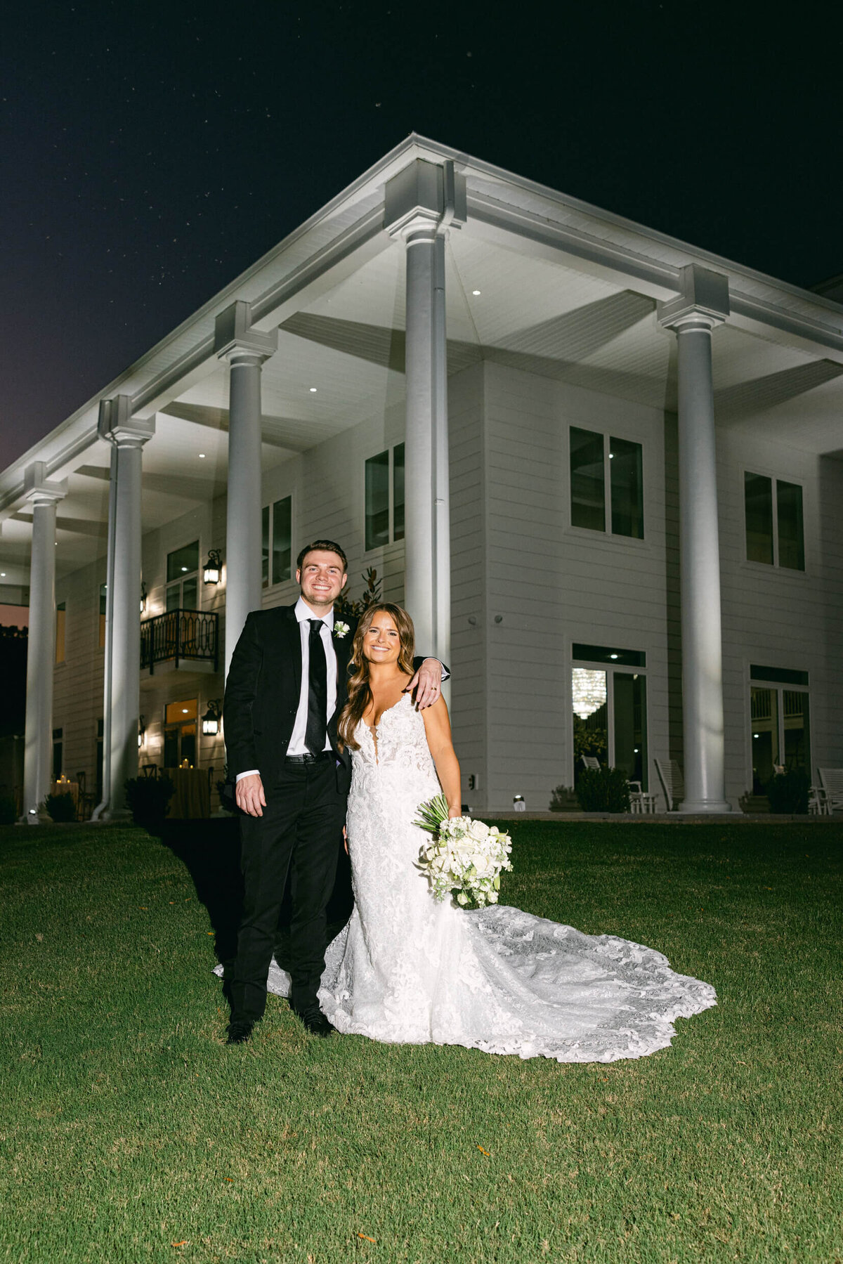 A wedding photo of the bride and groom in front of their wedding venue legacy acres