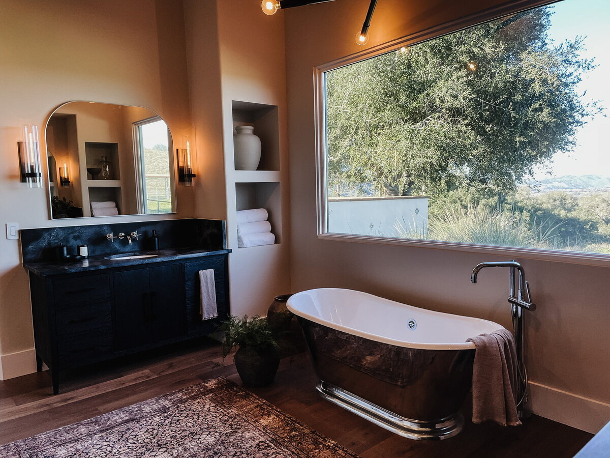 bathtub in front of large window