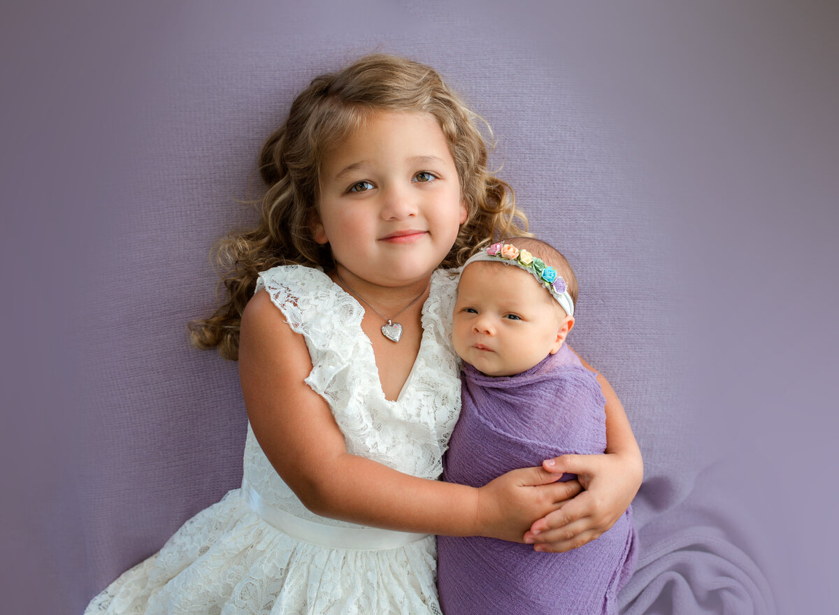 big-sister-with-newborn-girl-in-purple